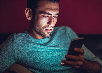 A person holding their phone and looking concerned