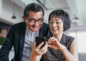 Two adults looking at a phone and smiling